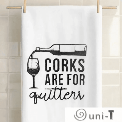 Corks are for Quitters Towel - Fun Kitchen Accessory hanging on a tiled wall. Embroidered design adds charm to any kitchen decor.
