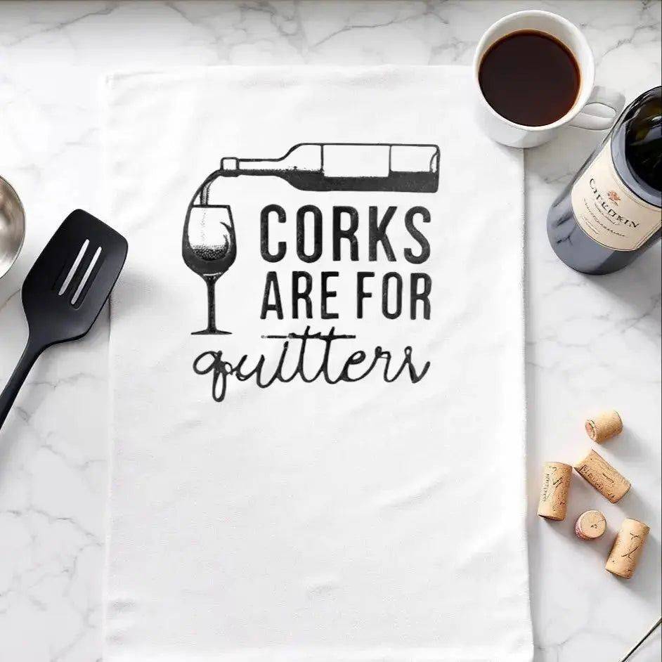 Corks are for Quitters Towel - Fun Kitchen Accessory displayed on marble counter with wine, corks, and utensils. Ideal humorous gift for wine lovers.