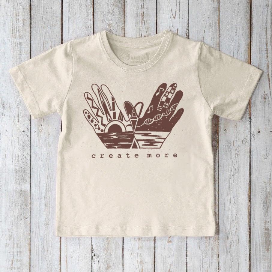 Beige Kids' Organic Cotton Graphic T-Shirt featuring 'Create More' hand design, sustainable and artistic top for young creators by Uni-T.