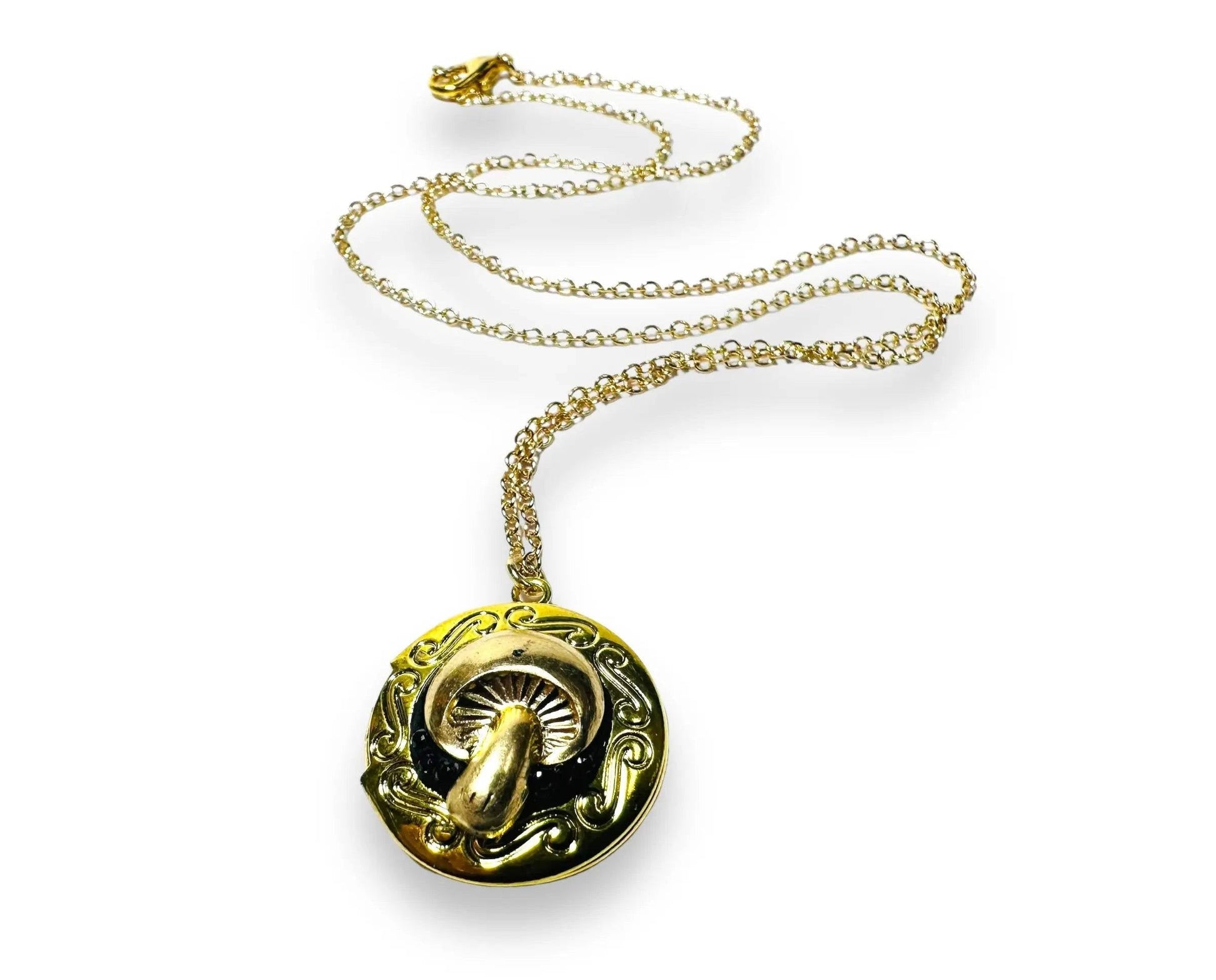 Round brass locket with ornate mushroom design and black crystal clay inlay, a whimsical and affordable gift option.