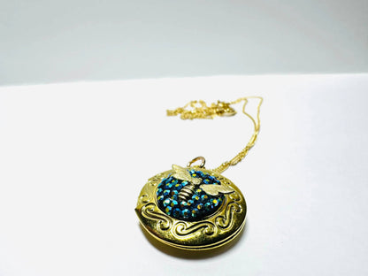 Round brass locket with ornate bee design and blue crystal clay, a standout piece in the affordable crystal locket collection.