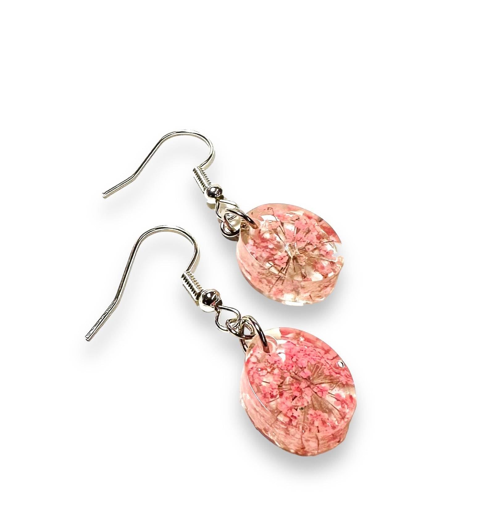 Small round resin earrings with pink flowers and silver hooks. Delicate pressed flower earrings for a subtle floral accent.