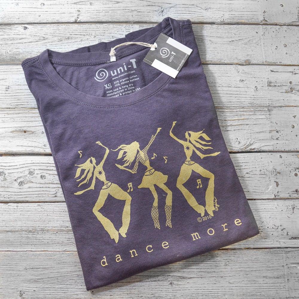 Folded Women's Dance More Long Sleeve T-Shirt in bamboo and organic cotton with gold dancing figures graphic by Uni-T, ideal for dancers.