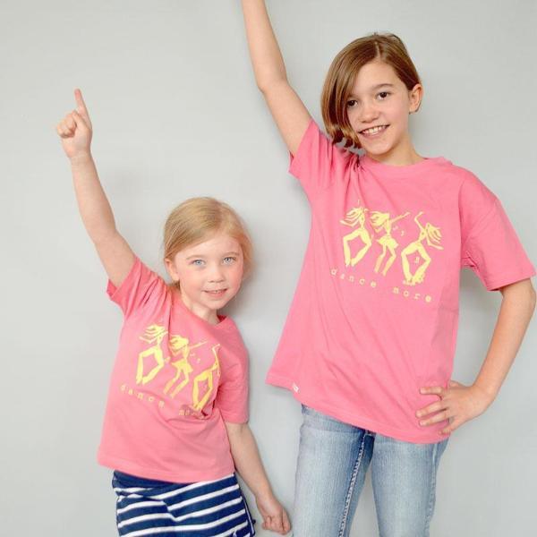 Two children wearing pink 'Dance More' organic cotton t-shirts by Uni-T, showcasing fun, active lifestyle apparel for kids.
