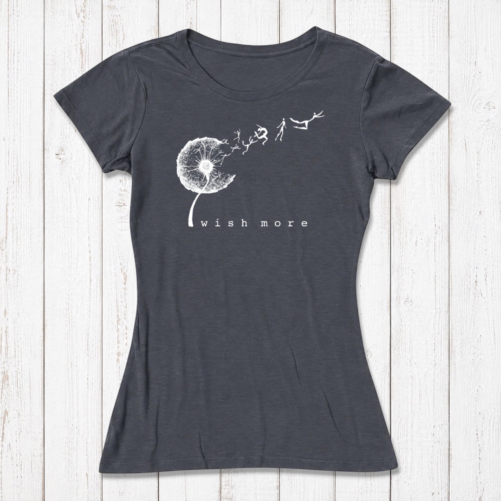 Navy blue women's graphic T-shirt with a white dandelion and flying seed design, featuring the phrase 'wish more' in lowercase letters, casual style