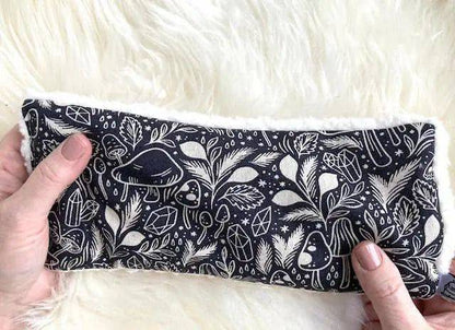 Hands holding Deep Rest Eye Pillow - Forest Forage with detailed forest-themed pattern, perfect for acupressure and soothing tired eyes.