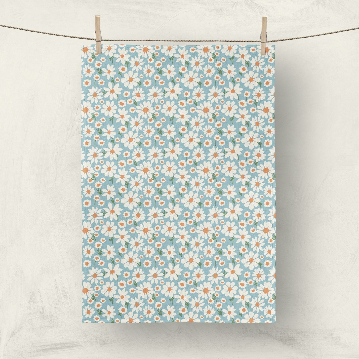 Daisy print fabric tea towel hanging on clothesline for home decor