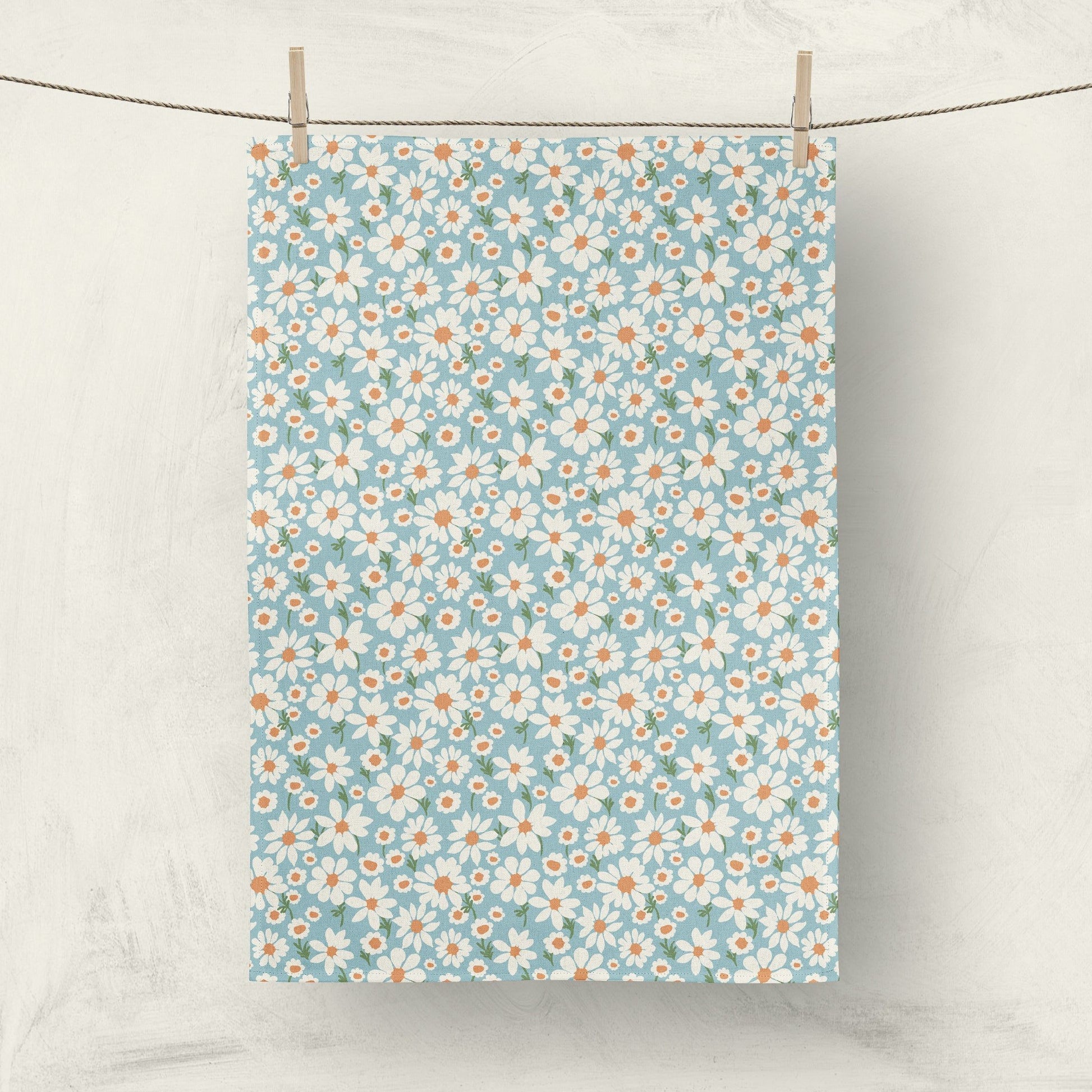 Daisy print fabric tea towel hanging on clothesline for home decor