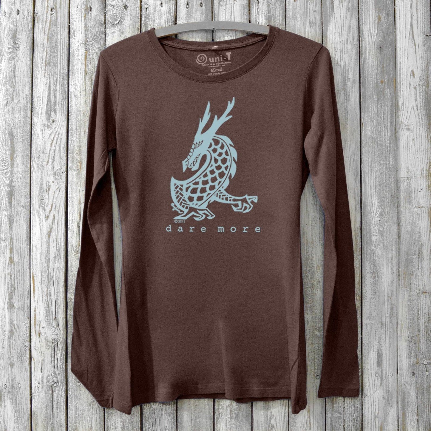 Women's Dragon Long Sleeve T-Shirt in bamboo and organic cotton, brown color with light blue dragon graphic and 'Dare More' text. Cozy fantasy art tee.