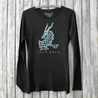 Black bamboo and organic cotton women's long sleeve T-shirt featuring a light blue dragon and 'Dare More' text. Eco-friendly adventure gift top.