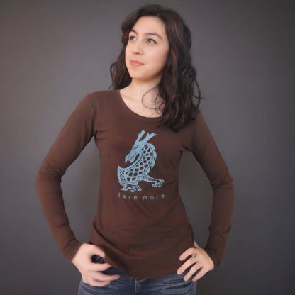 Model wearing brown 'Dare More' dragon long sleeve T-shirt made from bamboo and organic cotton. Stylish gift for adventurous women.