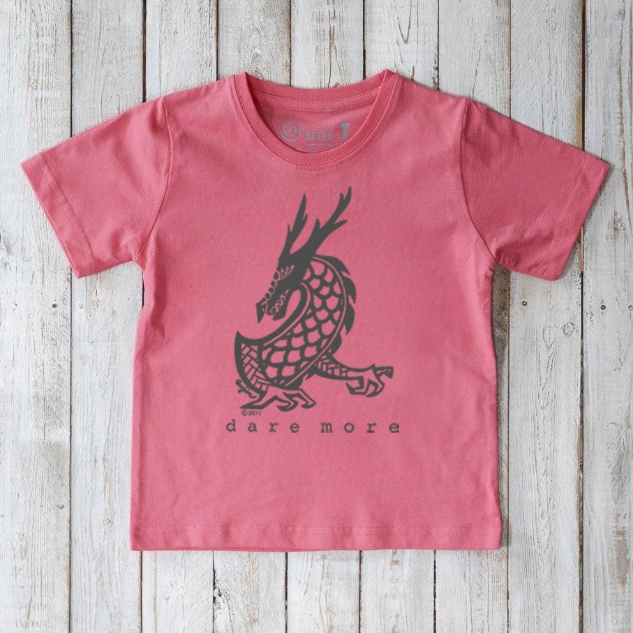 Coral pink Kids' Organic Cotton T-Shirt with black dragon design and 'dare more' print. Sustainable fantasy-themed top by Uni-T.