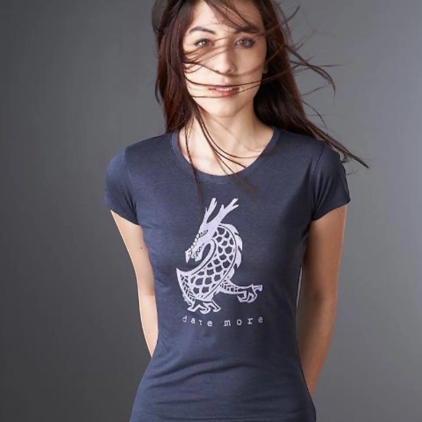 Woman wearing the 'Dare More' dragon T-shirt in navy blue, made from bamboo and organic cotton. Sustainable fantasy graphic tee for women by Uni-T.