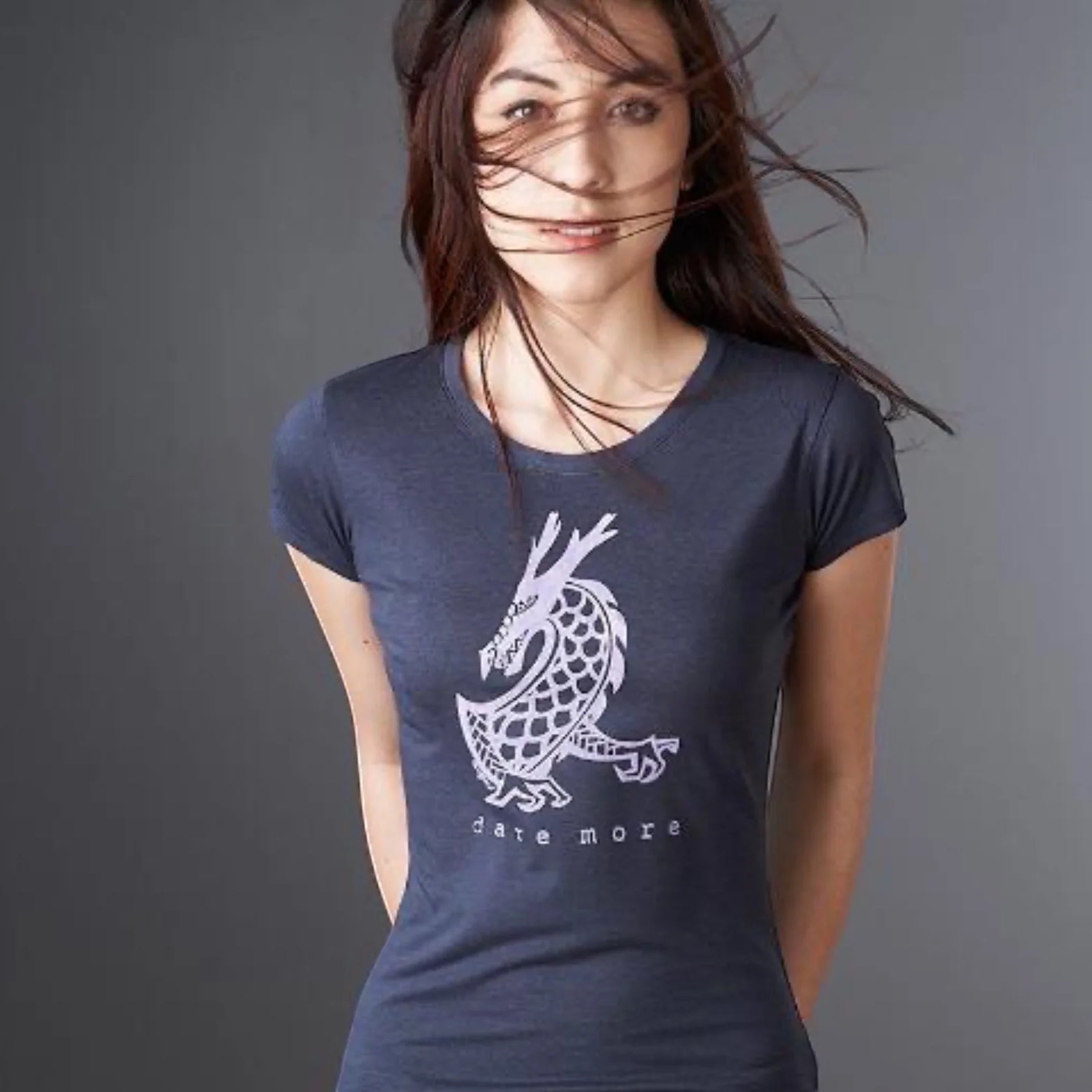 Woman wearing the 'Dare More' dragon T-shirt in navy blue, made from bamboo and organic cotton. Sustainable fantasy graphic tee for women by Uni-T.