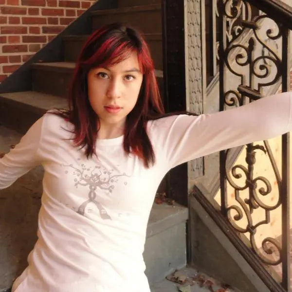 Young woman modeling white inspirational 'Dream More' graphic tee made from bamboo and organic cotton, ideal for casual motivation wear.