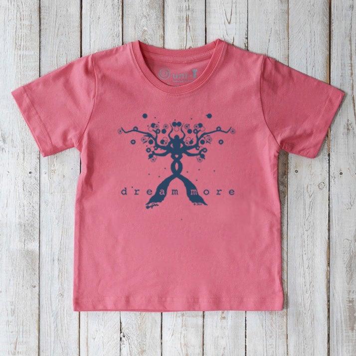 Pink Kids' Organic Cotton T-Shirt with blue 'Dream More' inspirational graphic. Eco-friendly and uplifting tee by Uni-T for young dreamers.