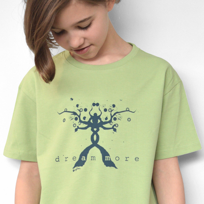Child wearing green Kids' Organic Cotton T-Shirt with blue 'Dream More' graphic. Eco-friendly inspirational top by Uni-T for children.