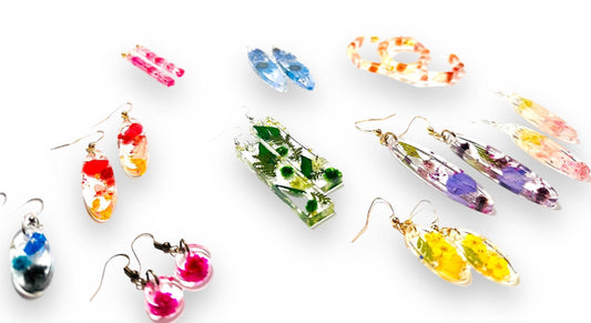Assorted pressed flower earrings in resin with gold and silver posts. Unique handmade real flower jewelry in various shapes and colors.