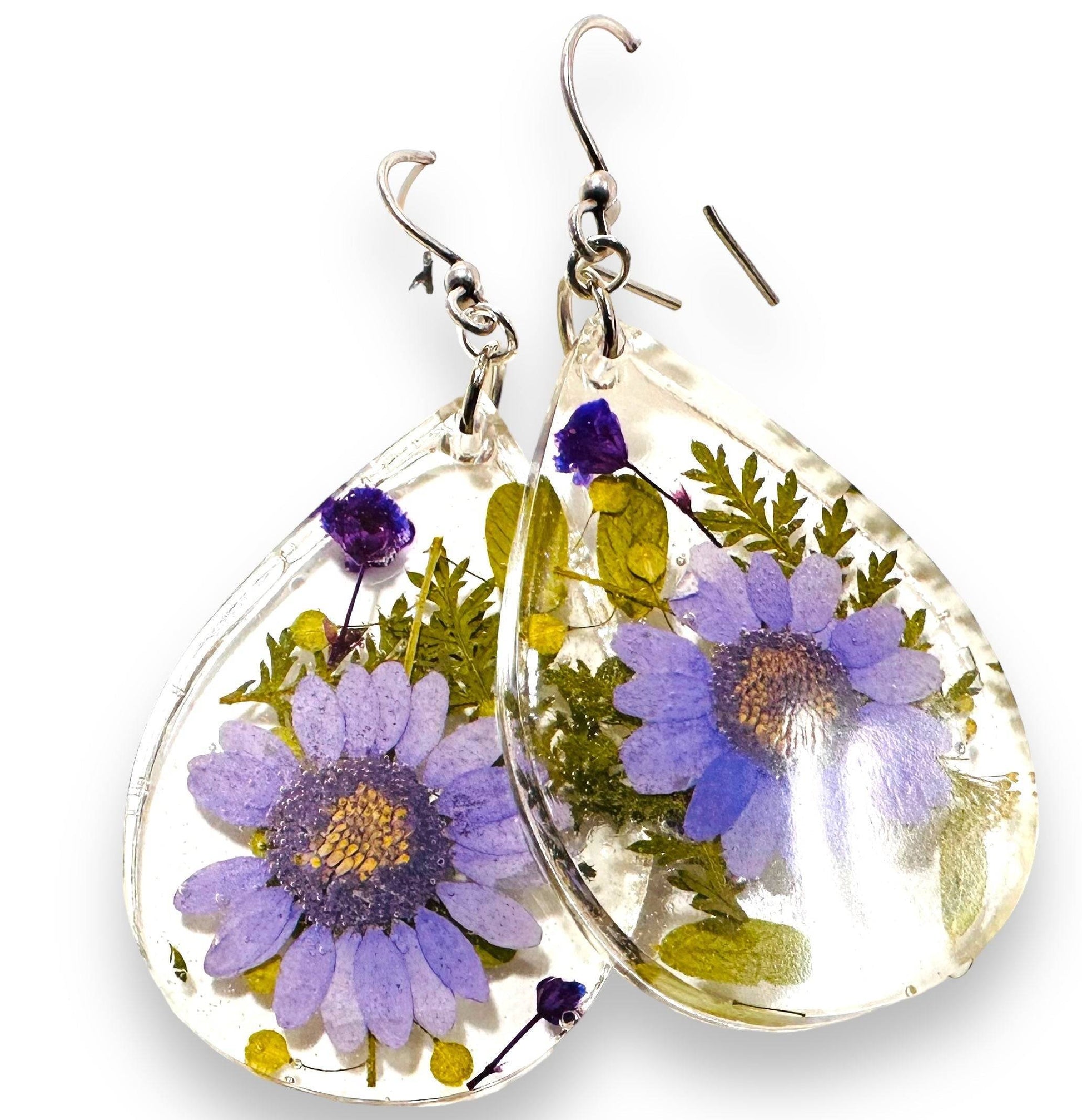 Teardrop resin earrings with purple daisy flowers and silver hooks. Real flower earrings with a soft botanical design.