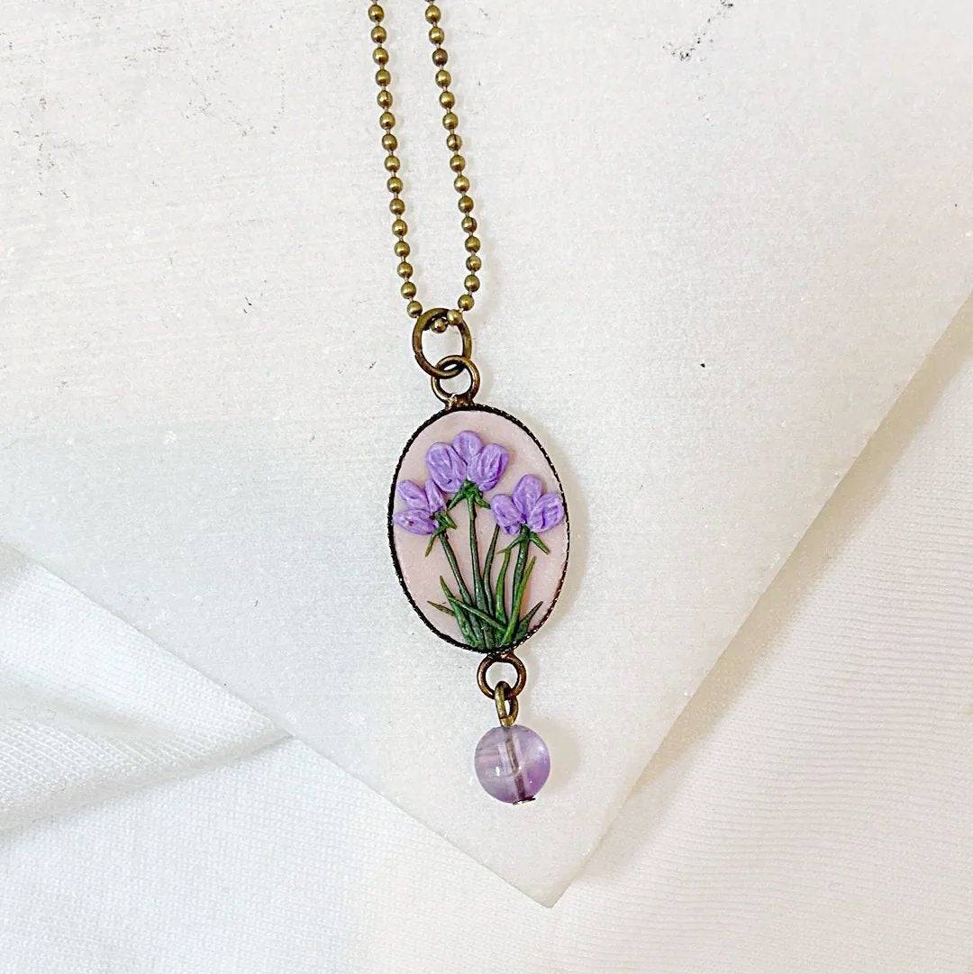 Uni-T Polymer Clay Floral Necklace featuring delicate purple flowers on a blush pink oval pendant, accented with a lavender gemstone bead.