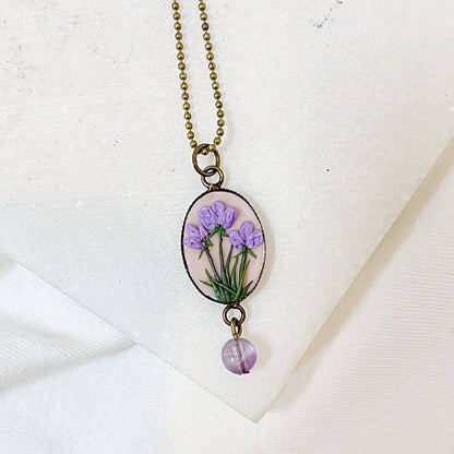 Uni-T Polymer Clay Floral Necklace featuring delicate purple flowers on a blush pink oval pendant, accented with a lavender gemstone bead.
