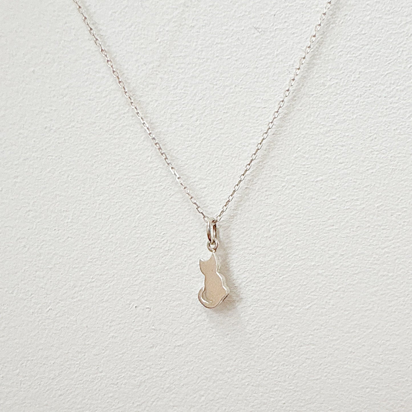 Silver kitty necklace on hand