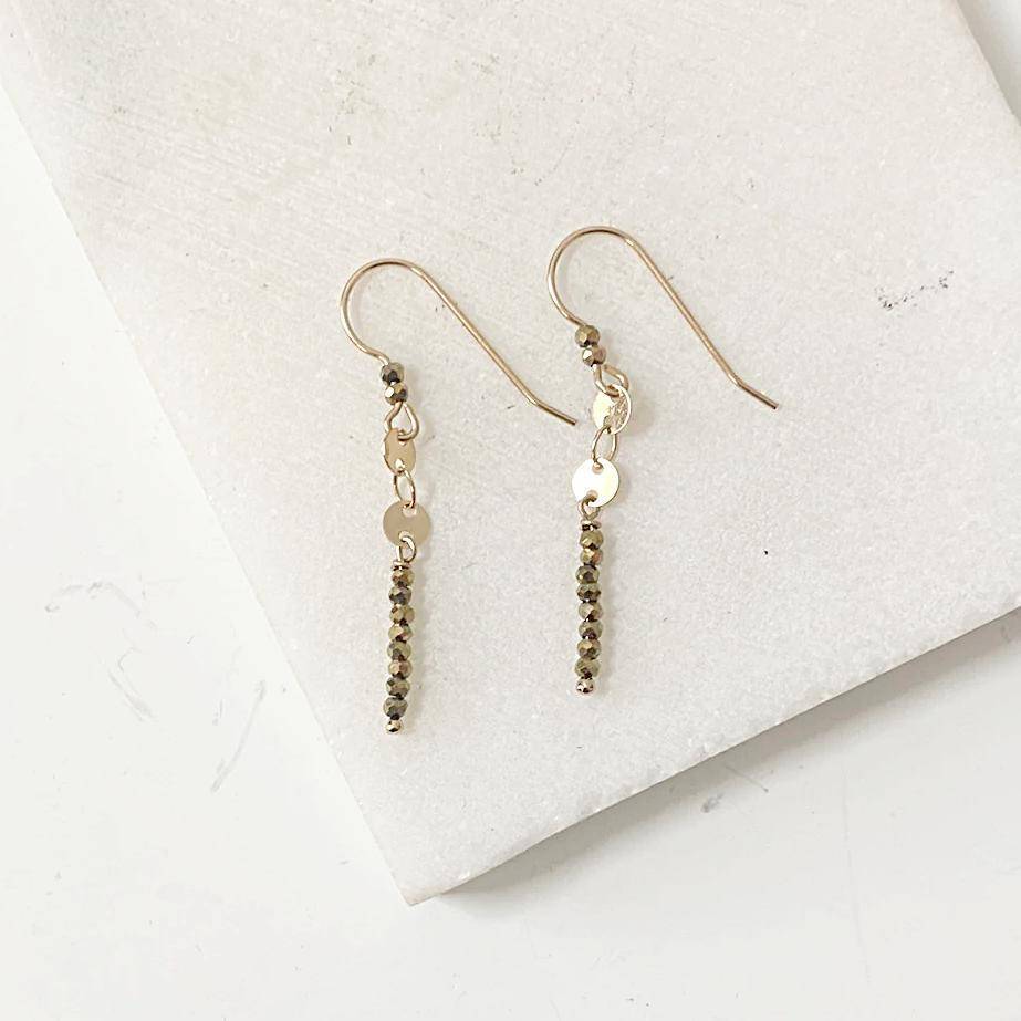 Dainty Gemstone Earrings - Gemstone Silver Earrings with hematite beads and gold hooks on white marble background. Elegant stick design for modern style.