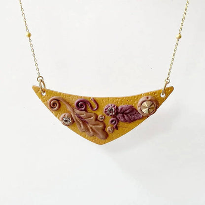 Autumn-themed Fall Leaves Bib Necklace with handcrafted polymer clay pendant, featuring intricate leaf details and gold chain. Stylish fall accessory.