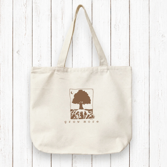 Organic canvas tote bag with 'Grow More' tree and roots artist design in blue ink. Eco-friendly and ideal for gardeners and sustainable living.