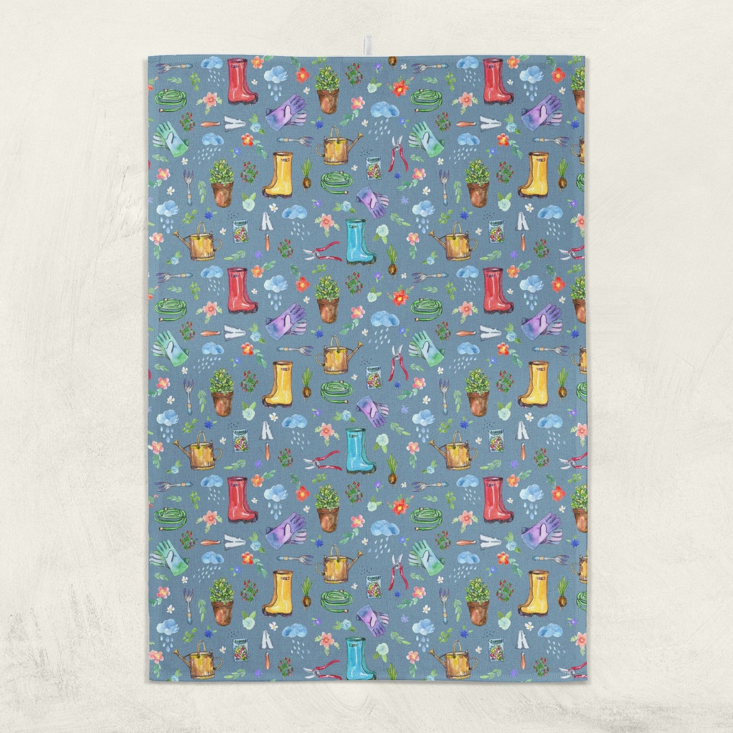 Garden Soul Tea Towel hanging on a wall with gardening pattern