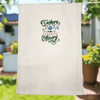 Embroidered Gardening Is My Favorite Therapy Towel hanging outdoors, perfect kitchen towel gift for gardening enthusiasts.