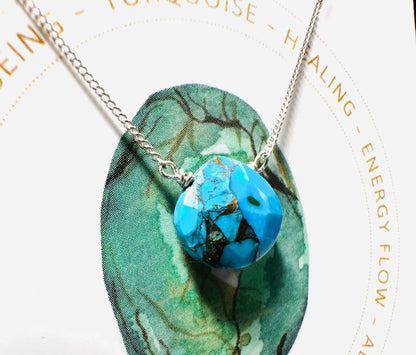 Turquoise teardrop pendant necklace on silver chain, symbolizing healing and energy flow, from handmade gemstone collection.