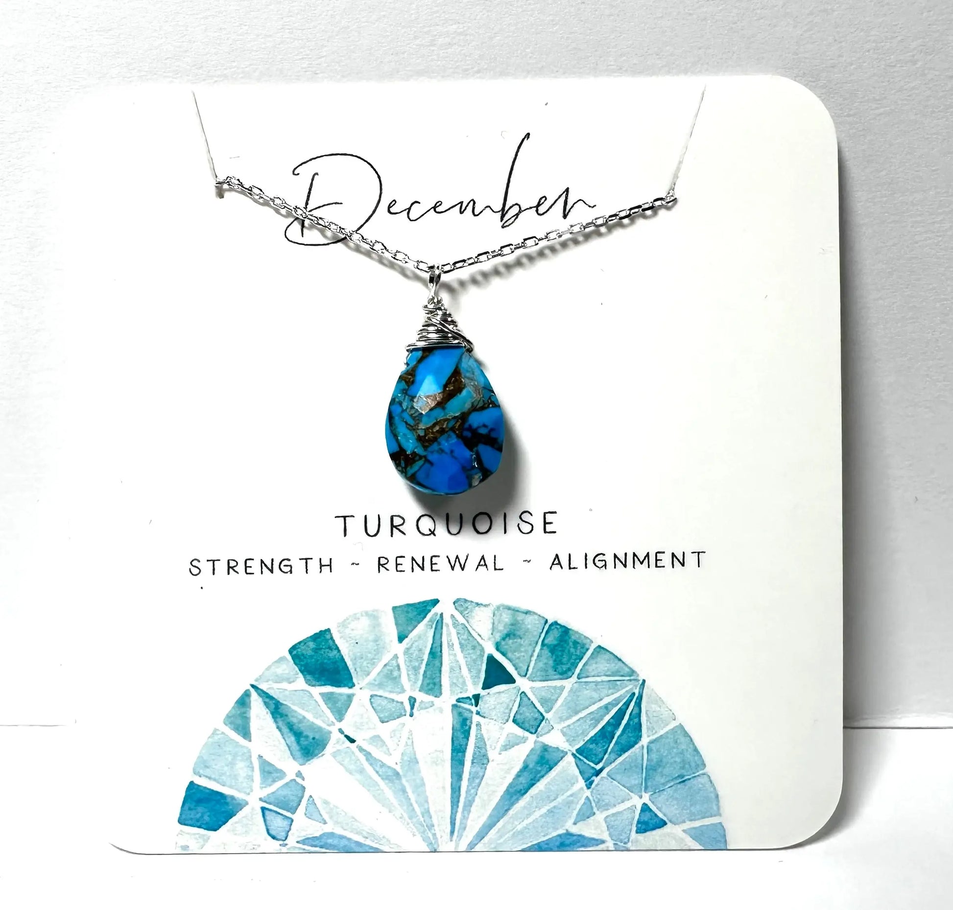 December birthstone necklace with turquoise teardrop pendant on silver chain, symbolizing strength and renewal.