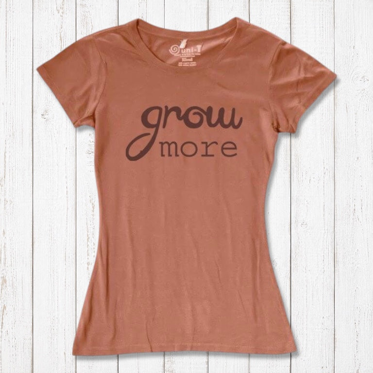 Rustic pink women's T-shirt with dark typography reading 'Grow More'. Sustainable bamboo and organic cotton tee for nature lovers.