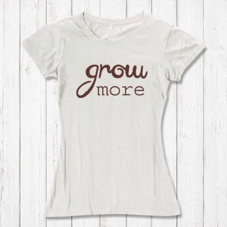 Cream-colored women's T-shirt with brown 'Grow More' typography. Eco-friendly bamboo and organic cotton tee for gardening lovers.