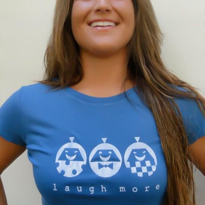 Blue Women's Organic Cotton T-Shirt with white 'Laugh More' quote and smiling cartoon faces. Fun and sustainable gift for her.
