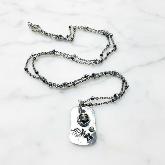 Silver necklace with a pendant on a white background