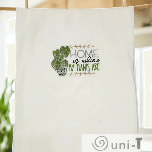 Hanging embroidered kitchen towel with green plant design and 'Home is where my plants are' quote. Great gift for plant lovers and home decorators.