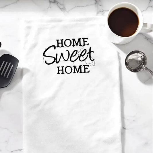 Massachusetts Embroidered Towel with 'Home Sweet Home' text displayed on a kitchen counter with coffee and utensils. Ideal kitchen decor gift.