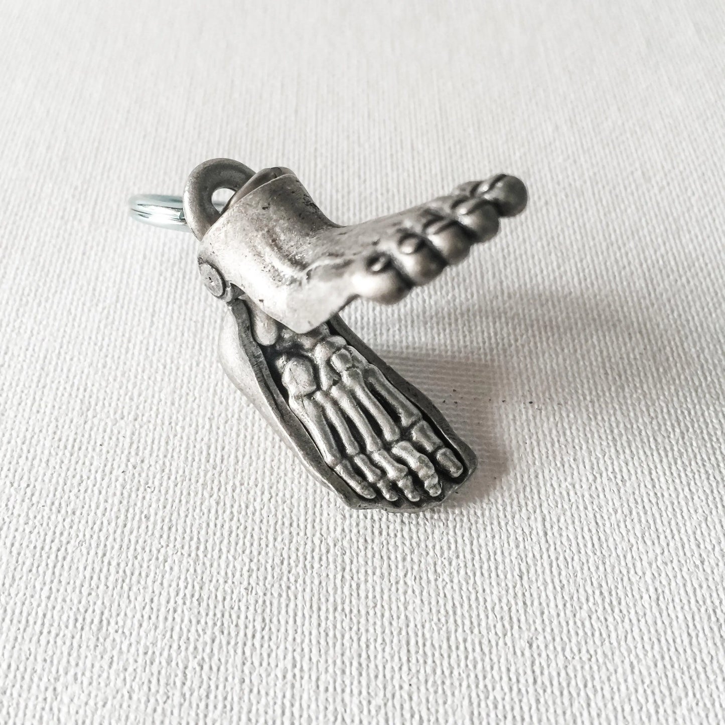 Anatomical Human Foot Keychain opened to reveal detailed skeletal structure. Unique accessory for medical or anatomy enthusiasts.