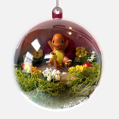 Uni-T Pokeball terrarium ornament featuring a Charmander figure inside a clear plastic sphere with moss and flowers