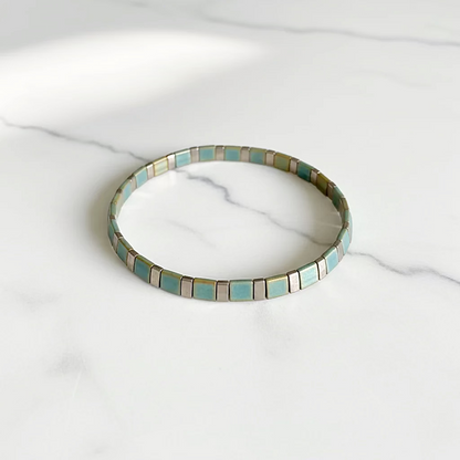 Flat Tile Bead Stretch Bracelet on white marble surface