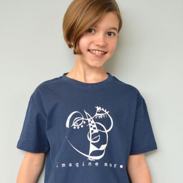 Smiling child in navy Kids' Organic Cotton T-Shirt with white abstract art and 'imagine more' slogan, eco-friendly inspirational clothing.
