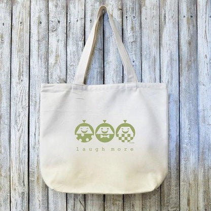 LAUGH MORE Canvas Tote - Organic Bag with artist-designed happy characters printed in green on natural cotton. Eco-friendly and perfect for gifting positivity.