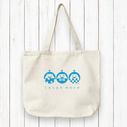 LAUGH MORE Canvas Tote - Organic Bag with artist-designed happy characters printed in green on natural cotton. Eco-friendly and perfect for gifting positivity.