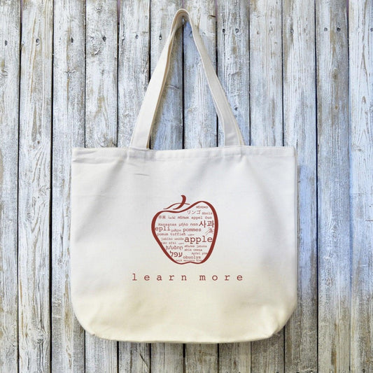 Teachers Gift Organic Canvas Tote with red apple word art and 'learn more' text. Eco-friendly bag ideal for educators and book lovers.