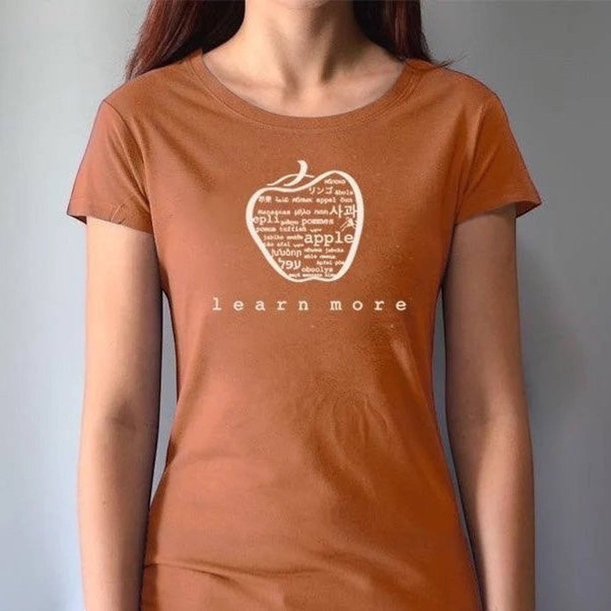 Rust orange women's bamboo & organic cotton T-shirt with apple 'learn more' graphic, inspirational gift for educators and mentors.
