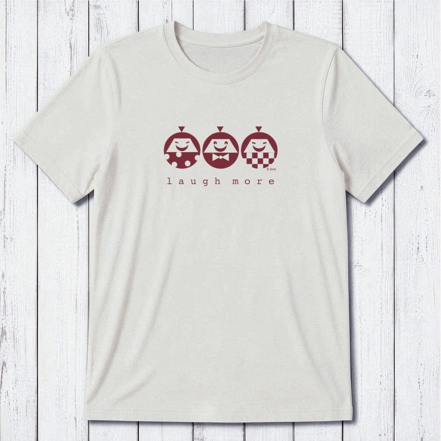 Men's Happy T-Shirt in Bamboo & Organic Cotton with 'Laugh More' quote and cartoon faces in maroon on cream. Eco-friendly funny gift tee.