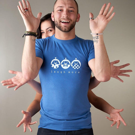 Men's Happy T-Shirt in Bamboo & Organic Cotton in blue with 'Laugh More' quote and white cartoon faces. Fun inspirational gift for him.