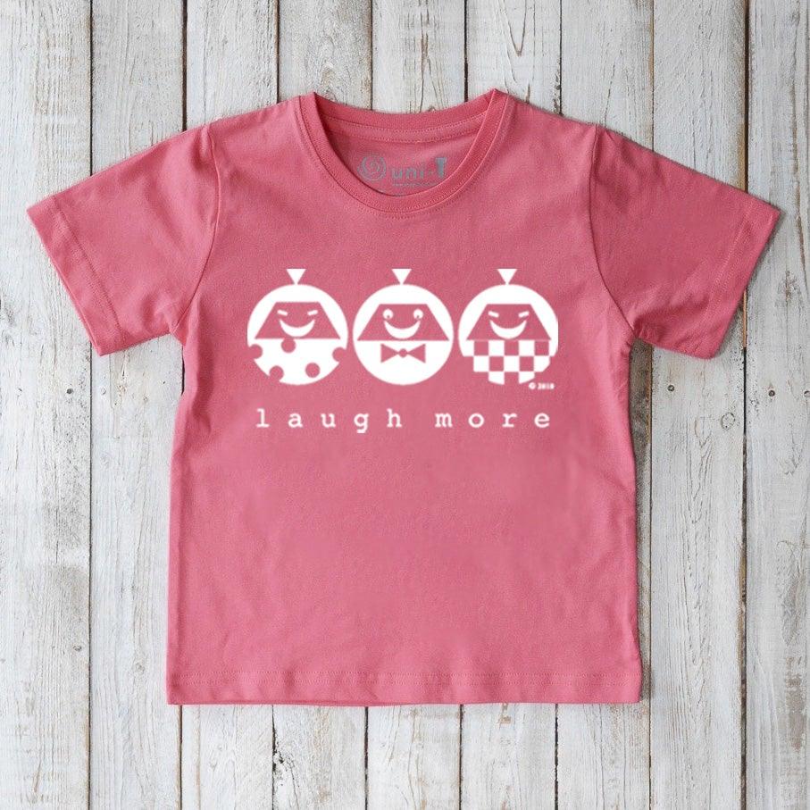 Pink Kids' Happy Vibe Organic Cotton T-Shirt featuring white 'Laugh More' characters. Eco-conscious playful shirt for kids by Uni-T.